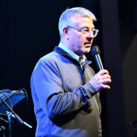Pastor speaking into a microphone at Lakeview Christian Church in Portage Lakes